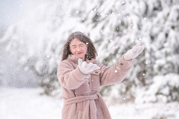 Portrait of a young beautiful girl in a winter forest.