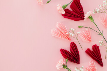 Happy Valentine's day ! Stylish pink and red hearts with gentle flowers flat lay on pink...