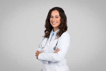 Portrait of confident female doctor in medical white uniform coat and stethoscope, posing with...