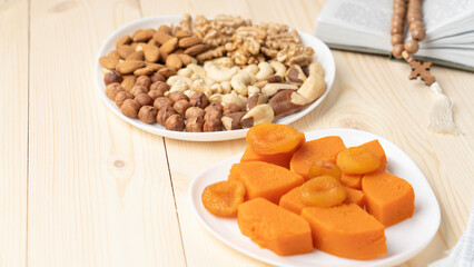 Boiled pumpkin and various nuts Lenten food in Lent on wooden background, nuts on plate, cashews, hazelnuts, almonds, walnuts