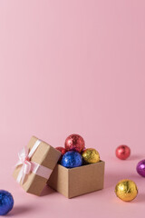Creative layout of colored candy and gift box on pink background