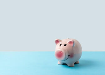 Piggy bank on blue table. Saving money concept.