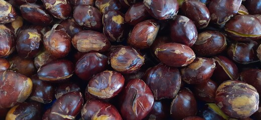 Obraz premium Close up of heap raw jengkol or dogfruit placed on stall of market ready to sold. Jengkol background