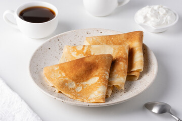 Thin pancakes in a plate. Concept of delicious breakfast or Maslenitsa