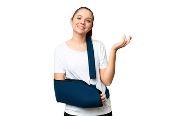 Young blonde woman with broken arm and wearing a sling over isolated chroma key background...