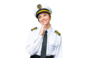 Airplane pilot woman over isolated chroma key background thinking an idea while looking up