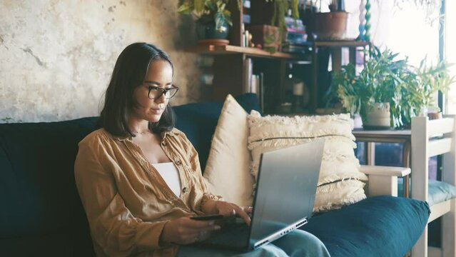 Woman, credit card and laptop for home online shopping, e commerce and fintech payment on sofa. Person typing on computer for internet banking, finance website and sign up for loan or savings account