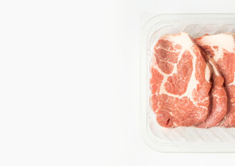 Fresh raw meat in package in plastic box. Close-up of meat in plate over light background with copy space