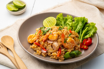 Seafood Tom Yum Fried Rice,Stir fried rice with shrimp and squid with chilli sauce on gray plate