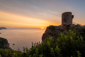 Fototapeta na wymiar Torre de Verger, on the island of Mallorca, Spain. A 16th century watchtower in the middle of nature with the sunset over the sea in the background