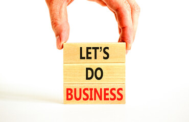 let is do business symbol. Concept words let is do business on beautiful wooden blocks. Beautiful white table white background. Businessman hand. let is do business concept. Copy space.