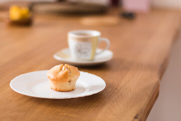 Fresh muffin with coffee for breakfast. Candel on the desk.