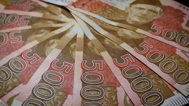 Bank notes of Pak Rupee in the denomination of 5000, rotating on an automatic table with a cinematic view.