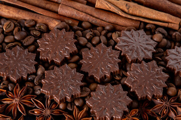 Food background. Coffee beans, cinnamon sticks, anise stars and chocolate candies top view.