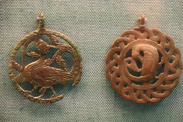 Medieval bronze pendants displayed in a cabinet