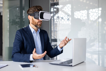 Businessman in suit using virtual reality headset at modern office desk, exploring vr technology
