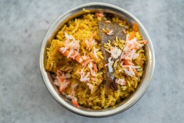 Spicy Indian biryani pulao in golden bowl with India basmati rice dish with chicken meat curry