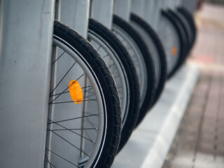 Bicycle wheels with orange reflectors in the parking lot - 709255968