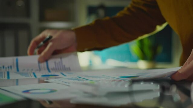Statistics. A business project expert in an employee uniform looks responsibly at profit charts in a meeting room. Senior manager studying indicator chart using modern technology, financial