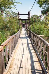 A long suspension pedestrian bridge with rusted metal structures in Lithuania.