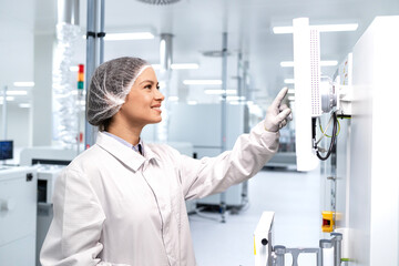 Technologist working in food factory and operating industrial machine for packaging.