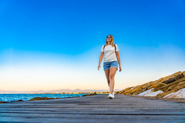 Woman walking on seaside boulevard - Costa Dorada Spain 