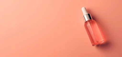 Poster A single glass dropper bottle filled with a peach-colored serum is displayed against a matching pastel peach backdrop, embodying simplicity and luxury in skincare. © Mirador