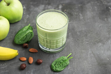 Green detox smoothie in a glass, blended vegetarian drink from spinach leaves, apple, banana fruit...