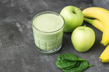 Green detox smoothie in a glass, blended vegetarian drink from spinach leaves, apple and banana...