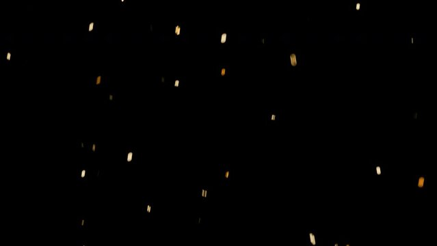 Golden confetti explosion and falling down on a black background. Christmas, birthday, holiday petard explosion.