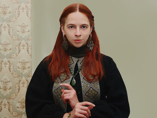 Selfie portraits of a red-haired woman in a jacket in ethnic Ukrainian style, green embroidered shirt on a white background.