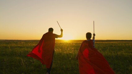 Dad and son playing superhero. Child, father waving a toy sword, childhood dreams. Child Game. Boy,...