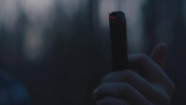 Man lighting and smoking a cigar outside during dusk