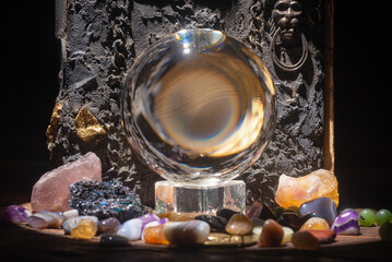Magic crystal ball and spell book on the wizard table close up background concept.