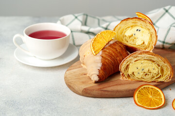 Fresh croissants with cup of tea on table