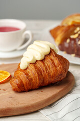 Fresh croissants with cup of tea on table