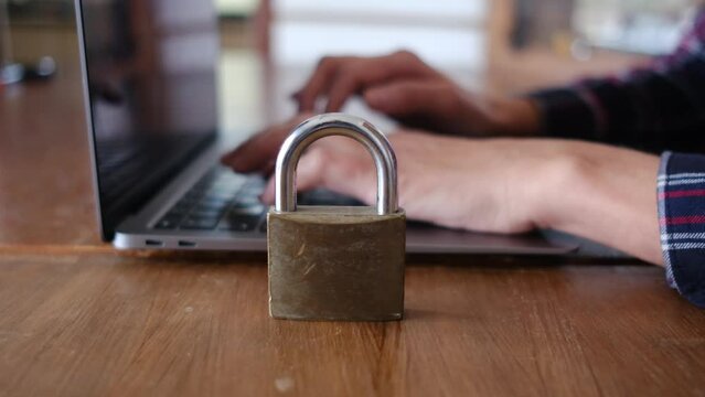 Woman typing laptop with padlock in front of computer security concept artificial intelligence secure internet. Person using laptop computer. Padlock on the desk.  Security concept.