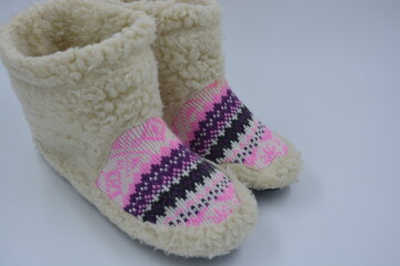 Beautiful, warm winter shoes, home shoes, slippers with black soles made by Ukrainian craftsmen from natural light wool located on a white working background.