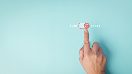 Hand pressing a digital start button on pastel blue background. Conceptual image of change, initiative decision and beginning action in minimalist design.