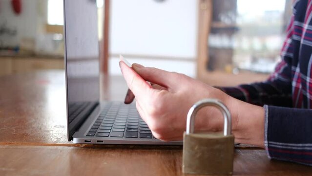 Woman typing on computer keyboard. Computer padlock card payment. Security and protection of secure payments, data security, security, and decentralization of transactions and data.