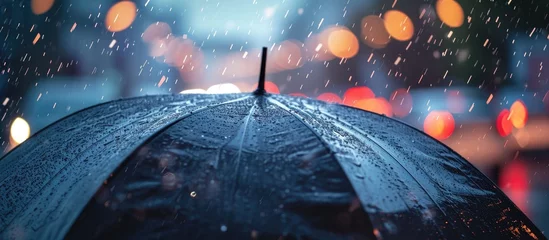 Fotobehang Rain and lightning on a black umbrella, with a blurred background. © AkuAku