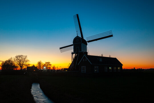 Classic windmill in Holland stands out against a colourful sky