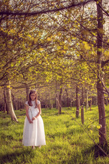 Obraz na płótnie Canvas Smiling girl happily celebrating her first communion in a natural and sunny environment