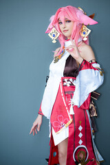 Female cosplayer in a pink anime costume wearing pink hair