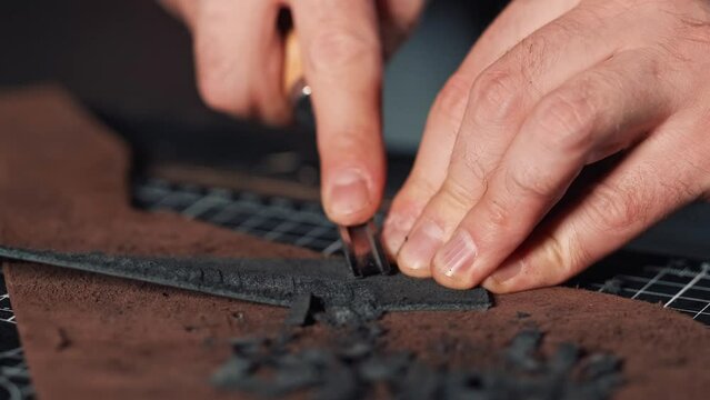 close-up of tanner'hands with bevel cutter chamfers edge of leather Working process of natural leather processing.