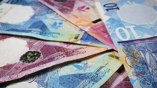 QAR or Riyals of Qatar, issued by Central bank of Qatar, rotating on an automatic display stand. Real Time, Smooth footage. 