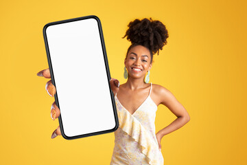Cheerful young african american woman in dress hold smartphone