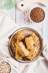 Pieces of halva with flax seeds on a plate on the table top and vertical view