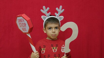 Sad child naughty boy questioning if Santa Claus will come this Christmas. High quality photo