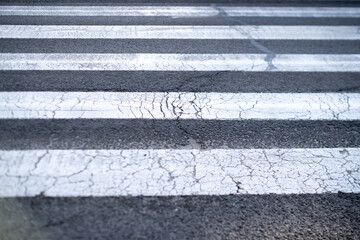 white pedestrian crossing lines on asphalt